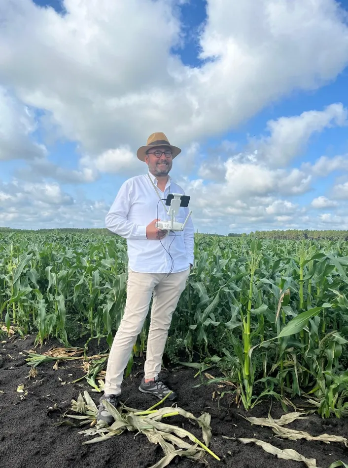 Luis Valdez en un maizal, con el mando del dron en las manos